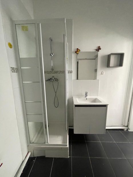 Cabine de douche et meuble vasque dans une salle d'eau